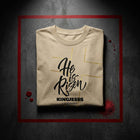 He Is Risen oversized tee — folded flat lay on dark concrete surface